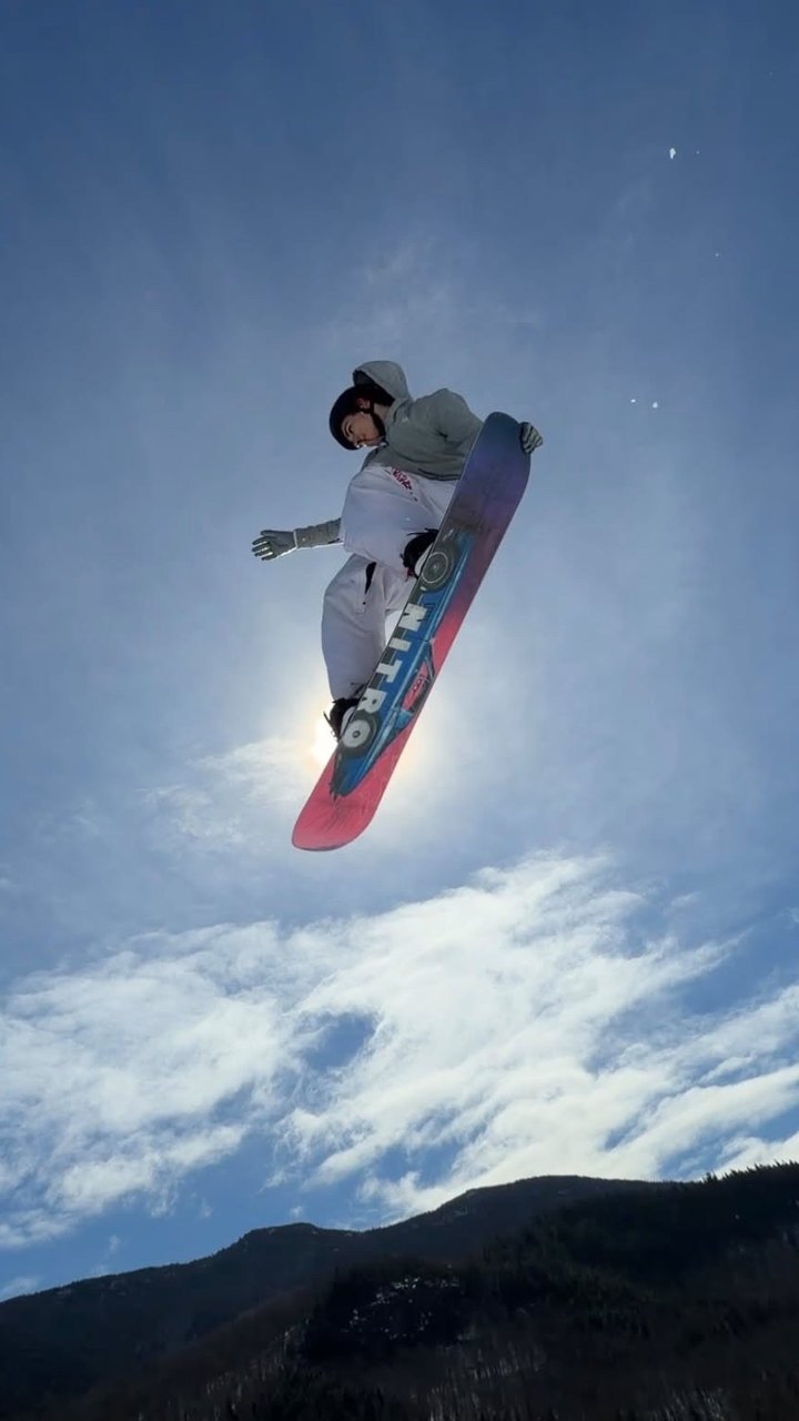 Snowboarder mid-air in Trashbags snow pants