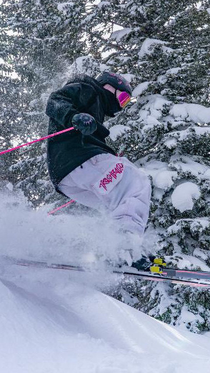 Skier blasting through powder in Trashbags snow pants
